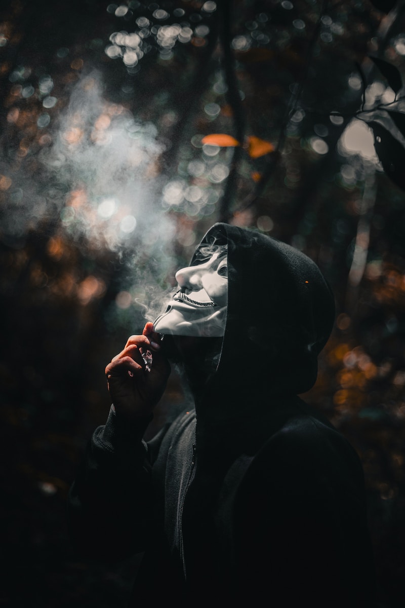 a person in a hooded jacket smoking a vape