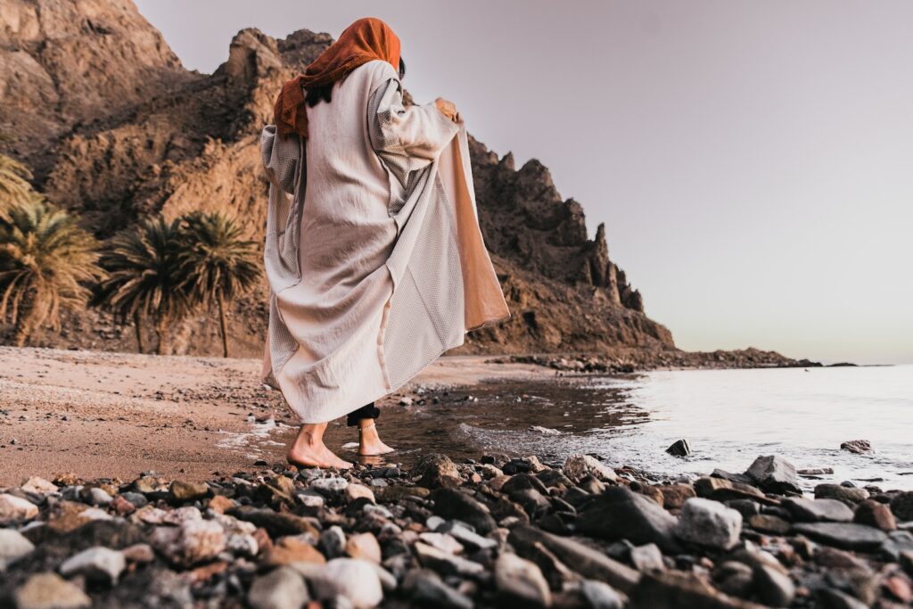 a woman standing on a rocky beach next to a lifestyle guru